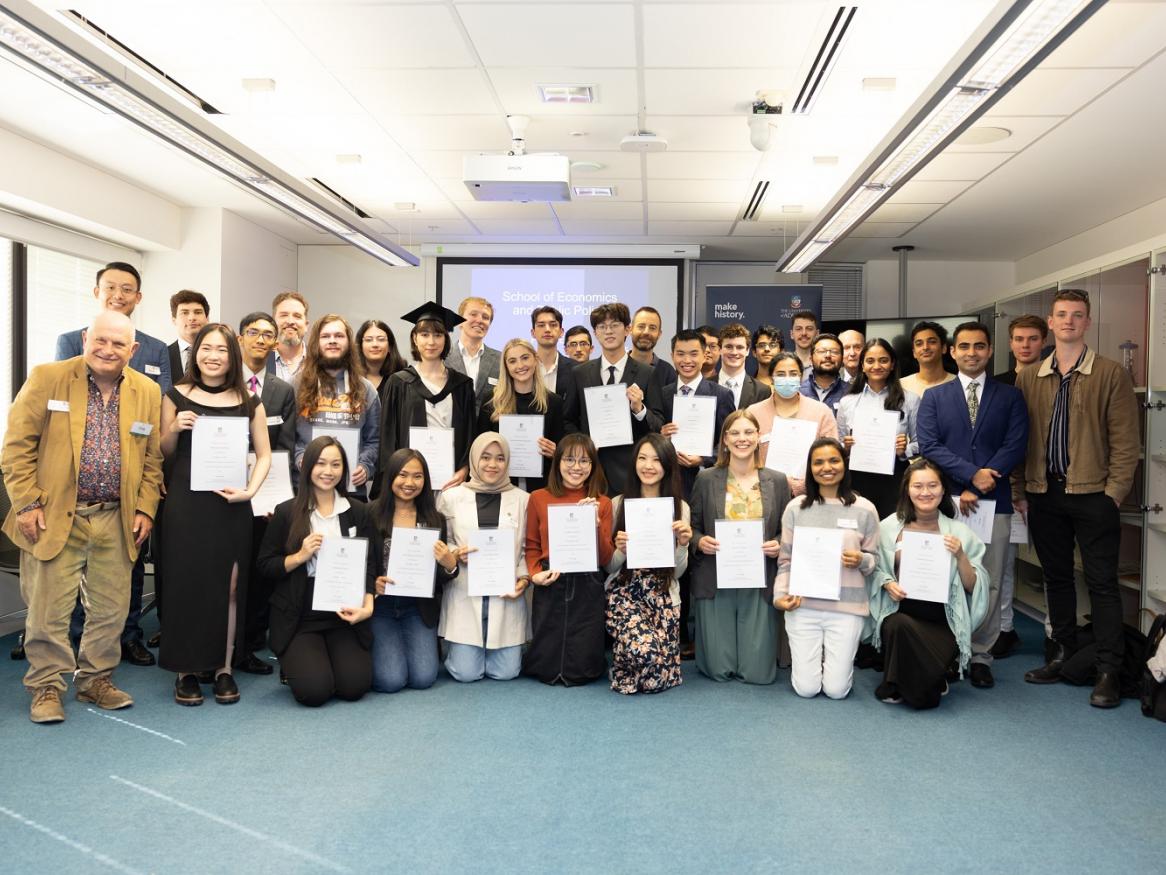 A group of students pose with their certificates at the School of Economics & Public Policy 2024 Prize Event