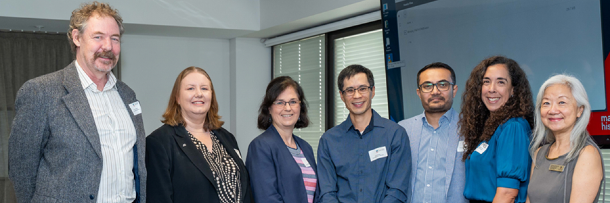 A group of academics stand and smile at the Federal Budget Recap 2025