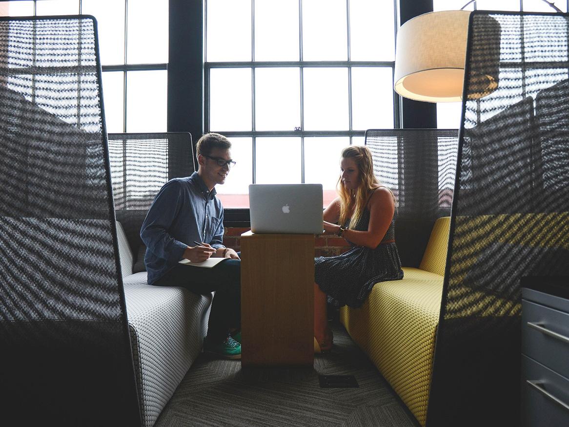 Two people sitting at a laptop