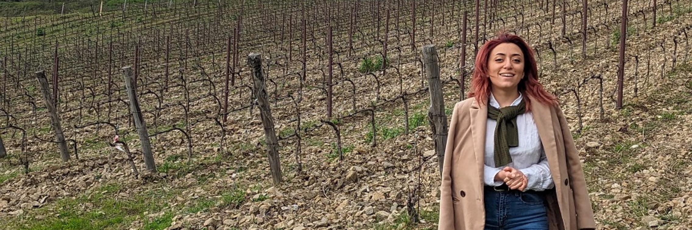 Syuzanna Mosikyan at a Chianti vineyard, with grey clouds above.