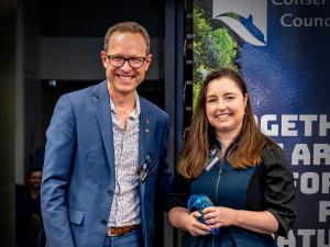 Sarah Wheeler smiles and holds her Jill Hudson Award for Environmental Protection