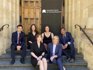 The Australian Centre for Housing Research group sit on the steps of Bonython Hall