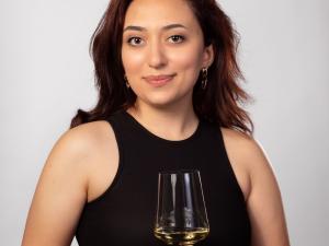 Syuzanna Mosikyan holds a glass of white wine.