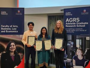 Ricky, Maggie, and Natalia hold their awards and smile.