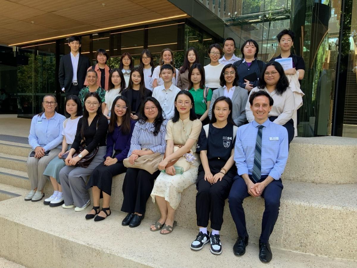 A group of teachers and education staff pose and smile at Adelaide Botanic High School