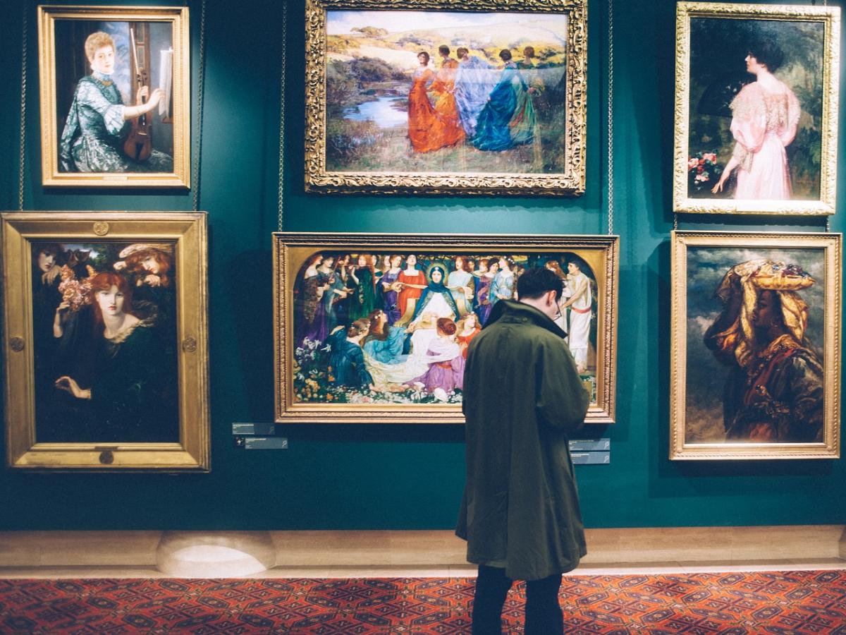 A person admires artwork in a museum