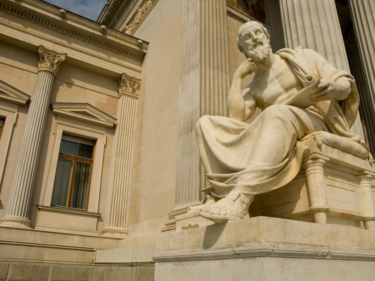 A statue of a man in front of white columns