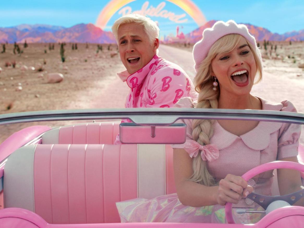 A scene from the Barbie movie shows Barbie and Ken driving in a pink car