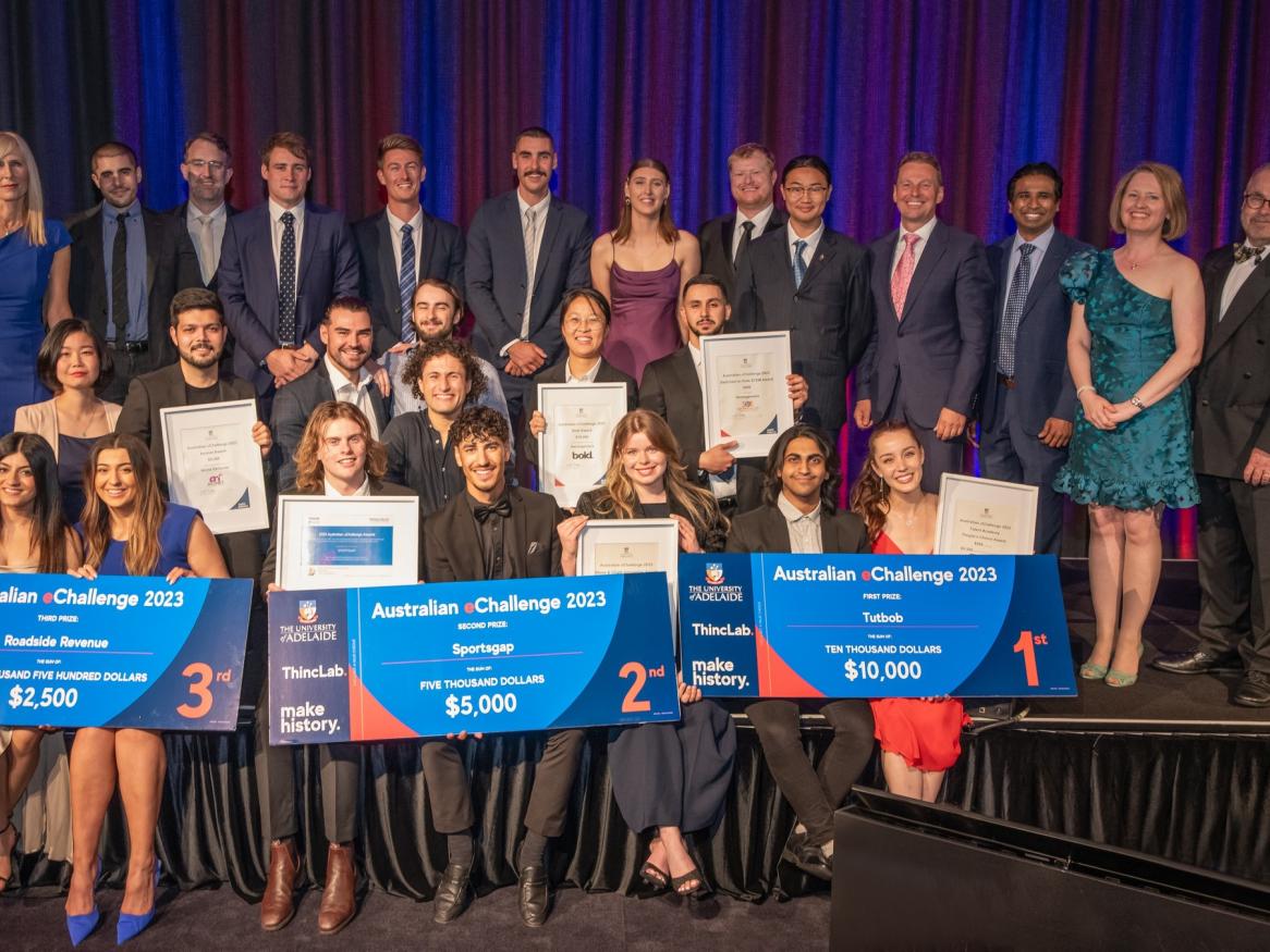 The 2023 Australian eChallenge participants on stage, some are holding novelty cheques