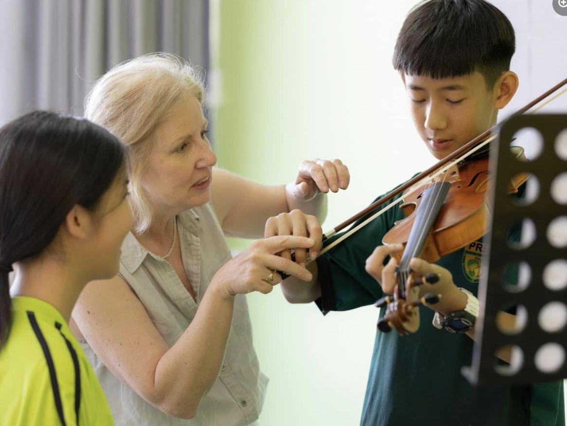 Dr Elizabeth Layton coaches a violin student in Bangkok