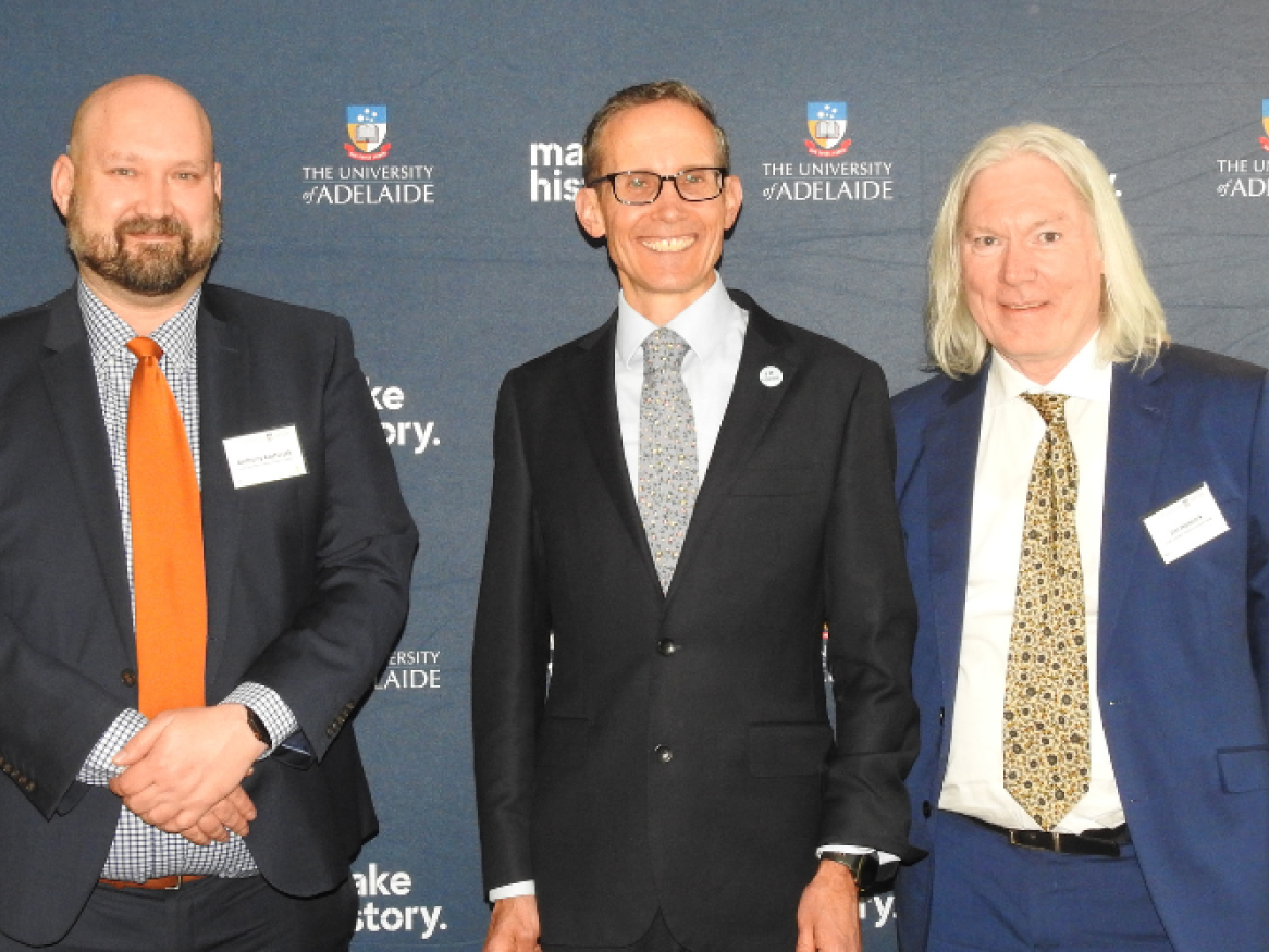 three men smiling at the camera